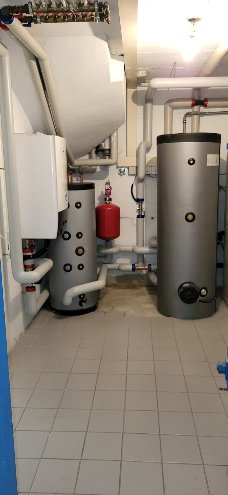 Renovated plant room with a Daikin hydraulic module and hot water tanks in Gilly, Vaud