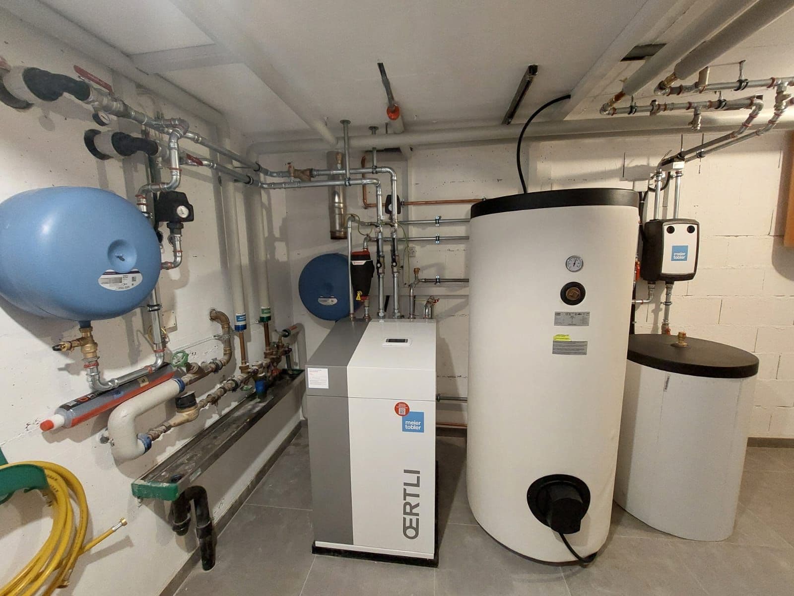 Plant room with an Oertli heat pump and hot water tank in Lonay, Vaud